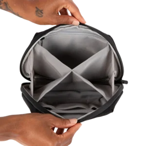 Hands holding open smell-proof stash bag revealing empty compartments for customizable storage.